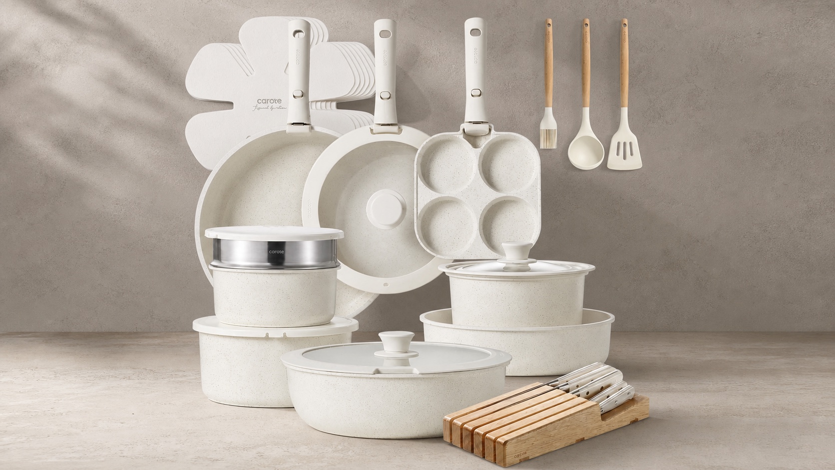 CAROTE Snow detachable cookware set arranged on a warm grey kitchen surface