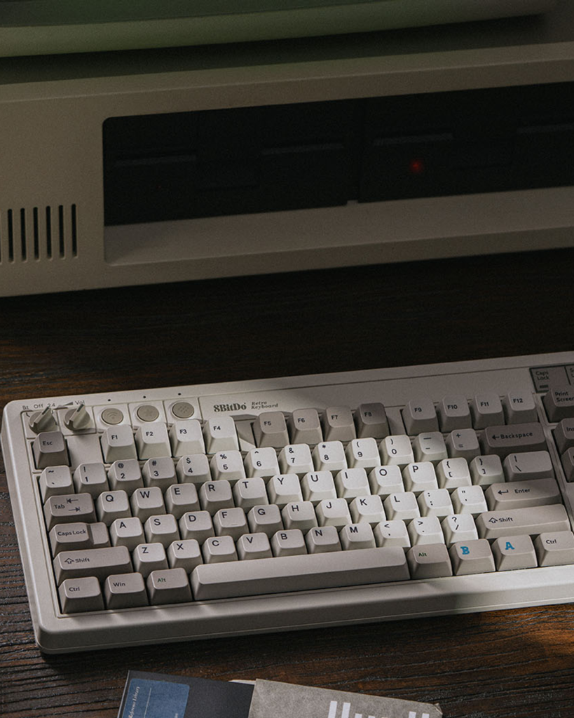 8BitDo Retro Mechanical Keyboard M Edition and Dual Super Buttons on a dark computer desk