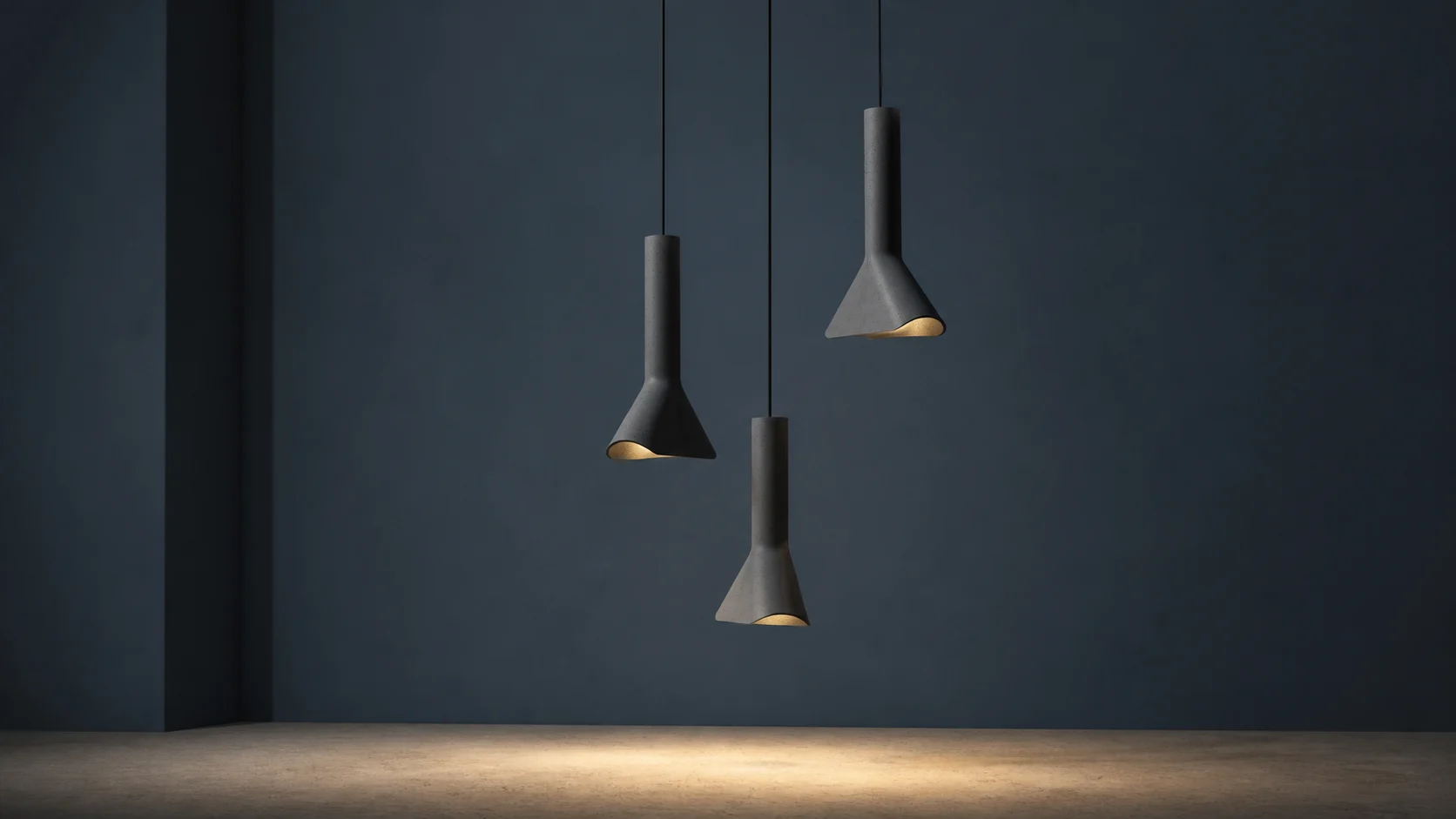 Three dark-grey BENTU RU concrete pendant lamps at staggered heights against a blue-grey wall