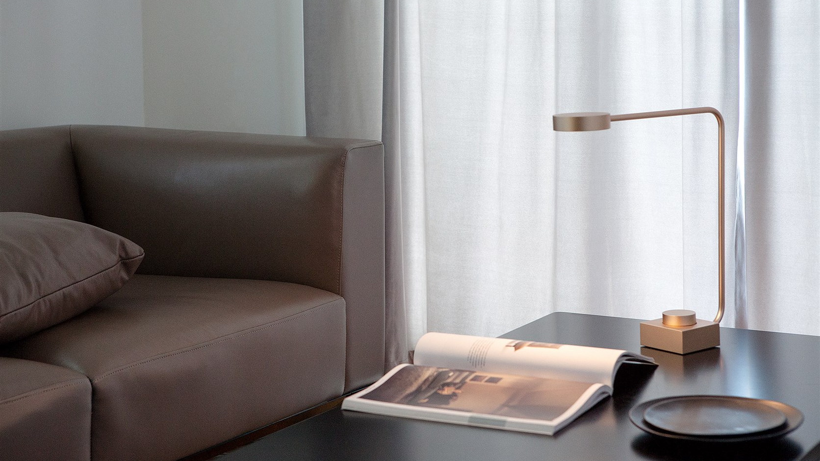 Complete rose-gold WUU T Reading Lamp beside an open book on a dark table