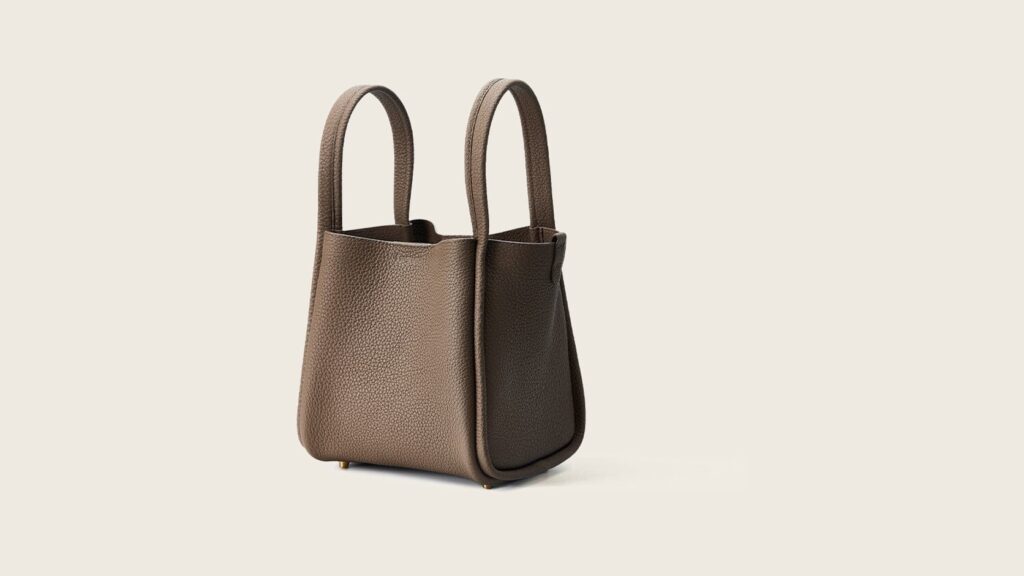 Complete taupe Songmont Medium Song Bag centred on a warm neutral background
